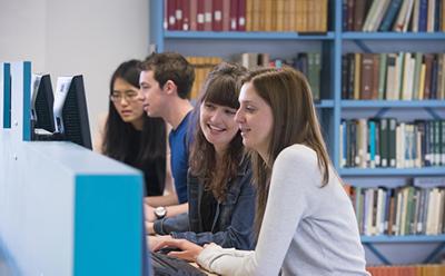A row of students using a shared workspace in the Hartley Library