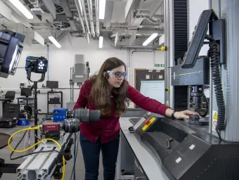 Student adjusting machinery in the Testing Structures Research Laboratory. 